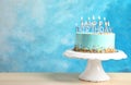 Fresh delicious birthday cake with candles on stand against color background. Royalty Free Stock Photo