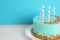 Fresh delicious birthday cake with candles on table against color background. Royalty Free Stock Photo