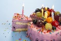 Fresh delicious birthday cake with candles on table against color background Royalty Free Stock Photo