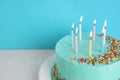 Fresh delicious birthday cake with candles on table against color background. Royalty Free Stock Photo