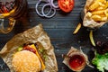 Fresh delicious burgers with french fries, sauce and beer on the wooden table top view Royalty Free Stock Photo