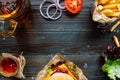 Fresh delicious burgers with french fries, sauce and beer on the wooden table top view Royalty Free Stock Photo