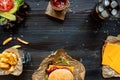 Fresh delicious burgers with french fries, sauce and beer on the wooden table top view Royalty Free Stock Photo