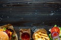 Fresh delicious burgers with french fries, sauce and drink on the wooden table top view, with copy space Royalty Free Stock Photo