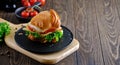 Fresh and delicious Croassan sandwich with green salad, tomatoes, cheese and scrambled eggs on a wooden board and a Royalty Free Stock Photo