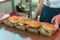 Fresh delicious grilled burgers on wooden table. Street food festival