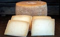 Fresh delicious healthy Cheese Wheel, with four Cheese Slices in foreground