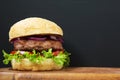 Fresh and delicious home made burger on wooden board with copy space. Royalty Free Stock Photo