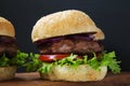 Fresh and delicious home made burgers on wooden board. Royalty Free Stock Photo