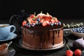 Fresh delicious homemade chocolate cake with berries on table against dark background Royalty Free Stock Photo