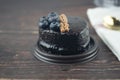 Fresh delicious homemade chocolate cake decor with berries on plastic box placed on wooden table Royalty Free Stock Photo