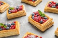 Fresh delicious puff pastry with sweet berries on grey