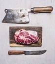 Fresh, delicious raw pork steak on a cutting board with a meat cleaver and a knife wooden rustic background top view close up Royalty Free Stock Photo