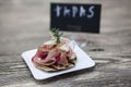 Fresh delicious Spanish tapas with hamon with fresh herbs and strawberries with poster TAPAS on the wooden background . Great bac Royalty Free Stock Photo