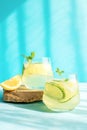 Fresh detox drink with cucumber and lemon slices, with mint in the hard rays of the sun. Summer cocktail. Healthy food