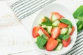 Fresh Detox Summer Spring Salad with Strawberries Green Mint Leaves in White Ceramic Bowl on Cotton Kitchen Towel