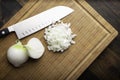 Fresh diced white onion on bamboo cutting board