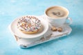 Fresh donut with cup of coffee on blue background