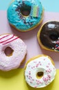 Fresh donuts with colored glaze on a colored background vertical. Multicolored donuts on a three-color background