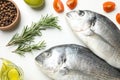 Fresh Dorado fishes and cooking ingredients on background, top view