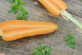 Fresh double cut carrot and herbs on wooden table Royalty Free Stock Photo