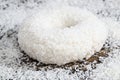 a fresh doughnut covered with white chocolate and coconut