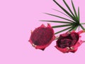 Fresh dragon fruit cut in half and leaf are sparse. Unfolded behind with the pink background..