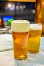 Fresh draught lager or IPA beer is glass served in indoor cafe close up, pint of beer Royalty Free Stock Photo