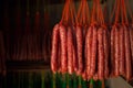 Fresh and dried Chinese sausages hang from racks