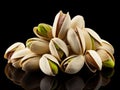Fresh dried pistachios in a hard shell with green nuts on black background