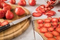 Fresh and dried strawberries from dehydrator for long term prepper pantry with knife, wooden cutting board and glass jar on light