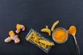 Fresh and dried turmeric roots and powder on black background. Top view, copy space Royalty Free Stock Photo