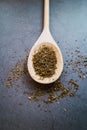 Fresh dry oregano and basil on wooden spoon with concrete background. Seasoning products. Close up view. Vertical picture Royalty Free Stock Photo