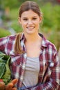 Fresh from the earth. Portrait of a happy young woman holding a crate full of freshly picked vegetables. Royalty Free Stock Photo