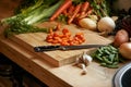 Fresh from the earth. a variety of vegetables and a knife on a cutting board.