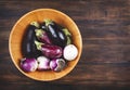 Fresh eggplants of different color and variety in wooden bowl on a wooden background Royalty Free Stock Photo