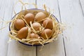Fresh eggs in enamel bowl on wood background