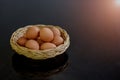 Fresh eggs in many wicker baskets on a black stone table prepared as a raw material for cooking.