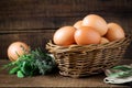 Fresh eggs in a willow basket with aromatic herbs