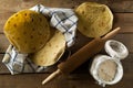 Fresh, empty wheat tortilla flat lay top view on dishcloth on rustic wooden table with flour and rolling pin