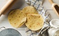 Fresh, empty wheat tortilla flat lay top view on dishcloth on rustic wooden table with flour, sieve, scoop and rolling pin