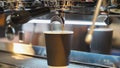 Fresh espresso. Close-up of flowing coffee from machine into paper cup. Scene in bar. Coffee culture, service, catering Royalty Free Stock Photo