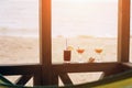 Fresh exotic cocktails on wooden edge. Shell lying between glasses. Cola with straw and lemon. Edge of house. View at