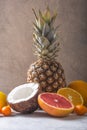 Fresh exotic fruits a on pastel grey  background - pineapple, grapefruit, coconut, orange. Mockup, flat lay, overhead. Top view Royalty Free Stock Photo