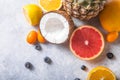 Fresh exotic fruits a on pastel grey  background - pineapple, grapefruit, coconut, orange. Mockup, flat lay, overhead. Top view Royalty Free Stock Photo