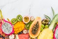 Fresh exotic fruits and tropical palm leaves on white marble background - papaya, mango, pineapple, passion fruit, dragon fruit, Royalty Free Stock Photo