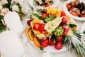 Fresh, exotic, organic fruits, light snacks in a plate on a buffet table. Assorted mini delicacies and snacks, restaurant food at Royalty Free Stock Photo