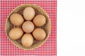 The Fresh farm eggs in wooden weave basket with red tablecloth isolated on white background, and copy space for your text Royalty Free Stock Photo