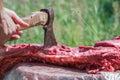 Fresh farm sheep carcase chopping by axe in man hand