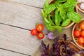 Fresh farmers tomatoes and basil on wood table Royalty Free Stock Photo